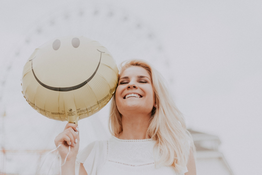 junge Frau mit Lufballon Smiley